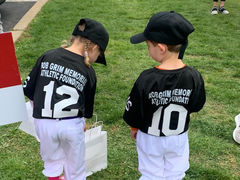 Two toddlers wearing jersey and cap